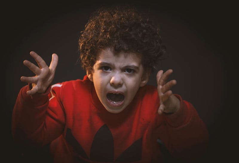 Angry toddler in red sweater screaming. Our child therapists in the Sacramento, CA area can help!