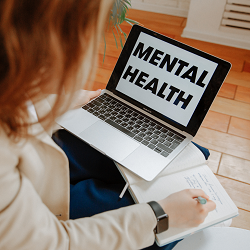 woman logs into a computer where the screen says mental health representing online co-parenting counseling in Sacramento, CA or online coparenting counseling in Fair Oaks, CA