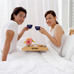 A couple sitting in bed drinking tea representing how couples can reconnect through sex therapy, online therapy or even a couples retreat. Relationship Therapy Center offers all of these services in California.