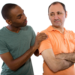 One man with an annoyed look with his husband looking around his shoulder to speak.  Our marriage counselors offer premarital counseling for gay &amp; lesbian couples.