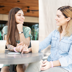two woman holding hands and smiling at each other after having an important conversation to stay connected | search for a therapist in Roseville, CA to help you communicate