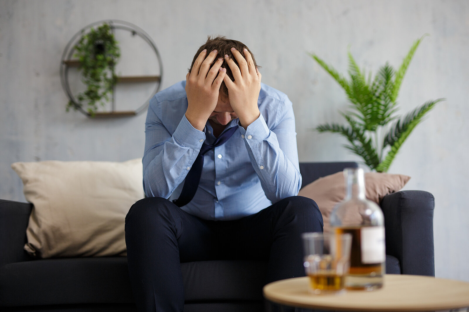 alcoholic man looks sad after having a drink. He gets addiction therapy in California and online therapy in California at the Relationship Therapy Center
