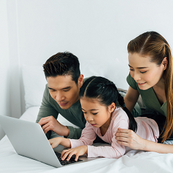 A family of three look at a laptop with intent. Therapy for children in Roseville, CA can learn more about teen therapy in California and other services. Learn more about our services by contacting a therapist for teens in Roseville, CA.