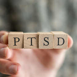 A close-up of a hand holding wooden blocks with the letters PTSD. Learn more about PTSD in Fair Oaks, CA and how a therapist for teens in Roseville, CA can offer support via trauma therapy in Roseville, CA. Search therapist for teens in Roseville, CA