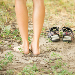 A close up of a person standing on the ground with their sandals nearby. Learn how anxiety treatment in Roseville, CA can offer support by contacting an anxiety therapist in Fair Oaks, CA today! 95678