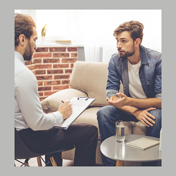 A therapist writes notes on their clipboard as a client sitting across from them talks. This could represent how a therapist in Fair Oaks, CA can help offer support with trauma therapy in Roseville, CA. Learn about depression treatment Roseville, CA.