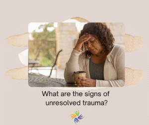 What are the signs of unresolved trauma? Image of a woman looking unhappy, sitting at a picnic table with a cup of coffee in one hand and her other hand on her forehead.  For trauma therapy, both in-person and online, contact The Relationship Therapy Center in Roseville and Fair Oaks California.